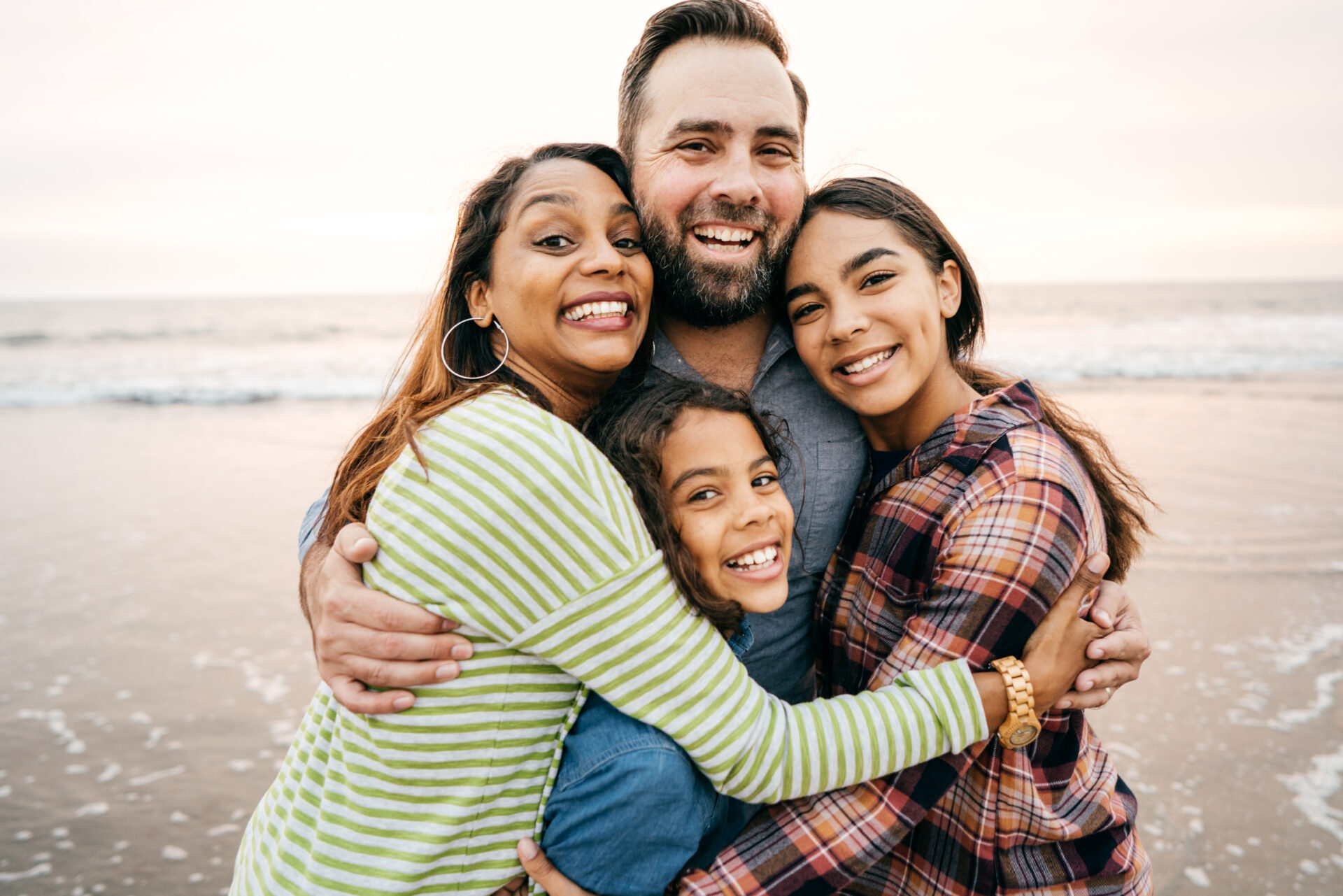 Smiling parents with two children on the beach